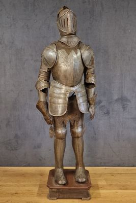 une statue représentant un homme en armure posée sur une table en bois