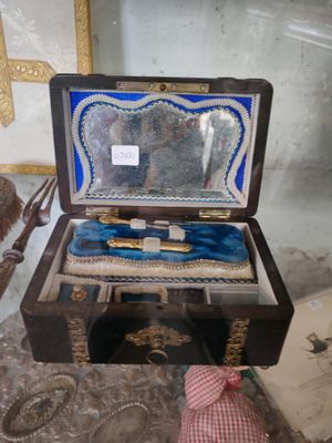 une petite boîte en bois contenant un tissu bleu et blanc