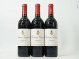 trois bouteilles de vin rouge sont alignées sur une surface blanche