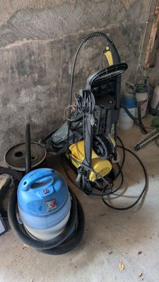 un aspirateur bleu et un bac bleu posés par terre