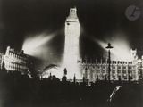 black and white photograph of a large clock tower lit up at night