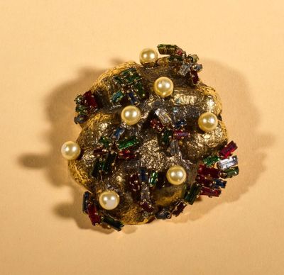 a brooch with pearls and jewels on it