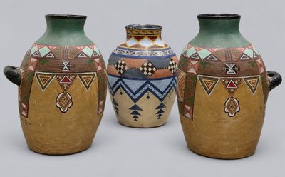 three vases sitting side by side on a gray surface