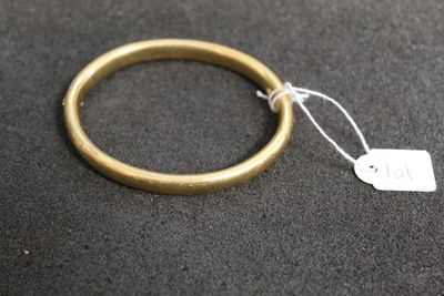 a gold ring with a tag on it on a black surface