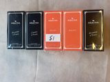 trois boîtes de parfum sont alignées sur une surface blanche