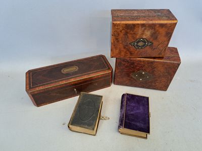 trois petites boîtes en bois et un petit livre posés sur une surface blanche