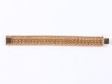 a close up of a gold bracelet on a white surface