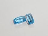 a pair of blue topazte gems sitting on top of a white surface