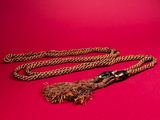 a close up of a rope with a tassel on a red background