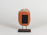 an orange and black stone with a black square on it