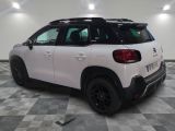 the rear end of a white citrole parked on a checkered floor