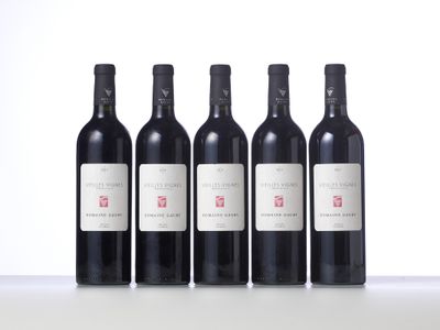 four bottles of wine are lined up on a table