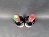 two bottles of wine that are sitting next to each other