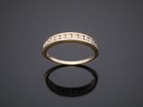 a yellow gold ring with diamonds on a black surface