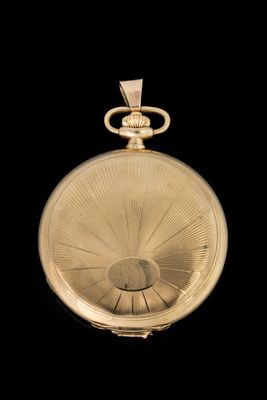 une image représentant une montre de poche en or sur fond noir