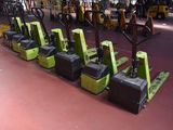 many yellow and black forklifts lined up in a warehouse