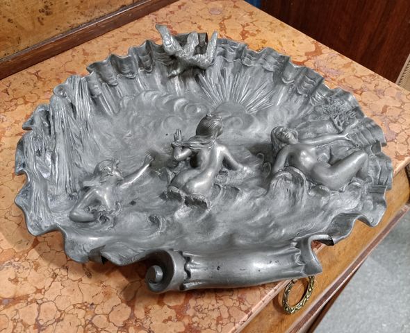 Plat en étain en forme de coquillage à décor en relief de naïades