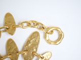 a close up of a gold bracelet with a butterfly on it