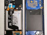 the back of a cell phone with a broken battery and a broken battery