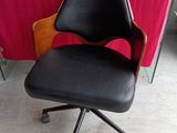a black office chair sitting in front of a red table