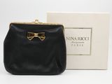 un petit sac à main noir orné d'un nœud doré sur le devant