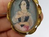 someone is holding a miniature picture of a woman in a dress