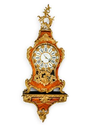 une horloge accrochée au mur, ornée d'une décoration dorée