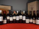 many bottles of wine sitting on a table with a red cloth