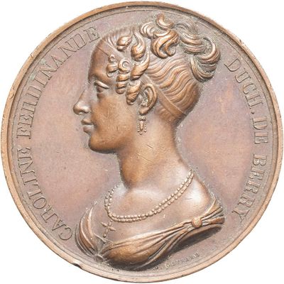 une ancienne médaille en bronze avec le profil d'une femme