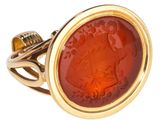 Gros plan sur une bague en or ornée d'une pierre rouge