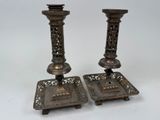pair of antique brass candlesticks with ornate design on bases