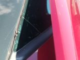 a red car with a broken windshield and a broken window