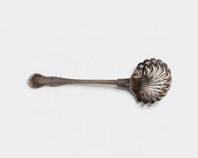 cuillère en argent ornée d'un motif floral sur un fond blanc