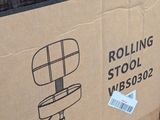 a cardboard box that has a rolling stool on top of it