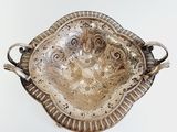 a silver tray with a handle and handles on a table