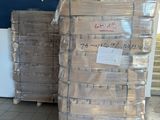 Plusieurs palettes de cartons sont empilées les unes sur les autres dans un entrepôt