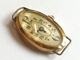 a small gold clock that is sitting on a white surface