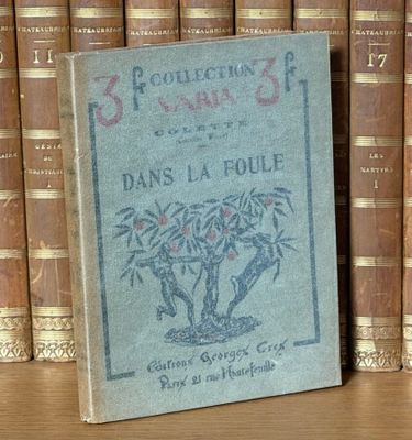 un livre posé sur une étagère, devant une pile de livres