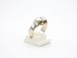 bague en argent massif posée sur un bloc de marbre blanc