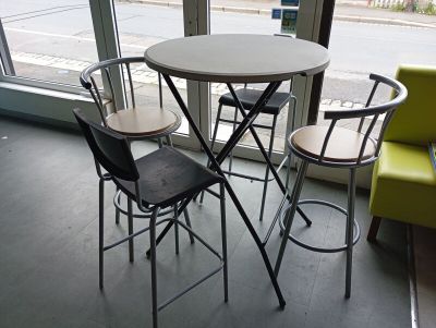 une table et quatre chaises devant une fenêtre