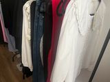 a lot of clothes hanging on a rack in a room