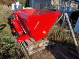 une benne rouge posée sur une palette en bois