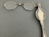 a close up of a pair of glasses and a spoon on a table
