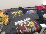 de nombreux t-shirts posés sur un lit dans une chambre