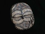 une image représentant un masque sculpté sur fond noir