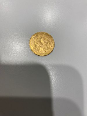 gros plan d'une pièce d'or sur une surface blanche