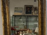 a mirror with a gold frame on the wall