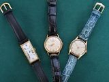 trois types de montres différents posés sur un fond vert