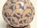 un vase bleu et beige posé sur un socle en bois