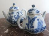 two blue and white teapots sitting on a table